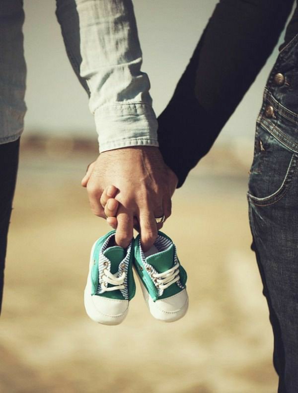 parents holding baby shoes 