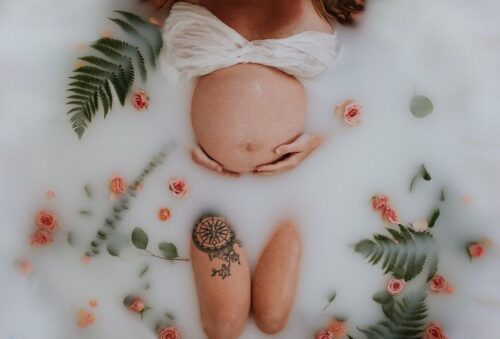 woman inside tub with pregnant belly poking out 