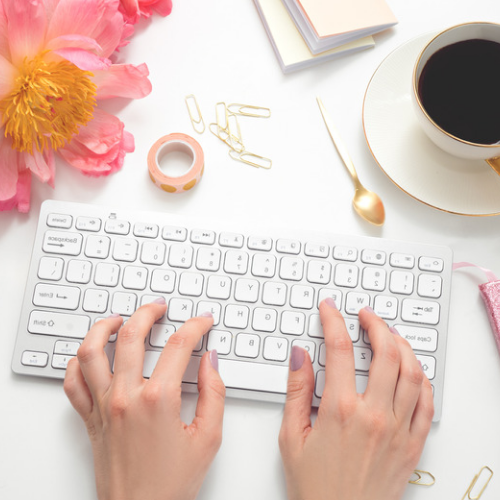 feminine pink desk scene woman typing 