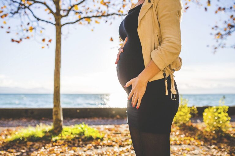 Pregnant woman standing with beach